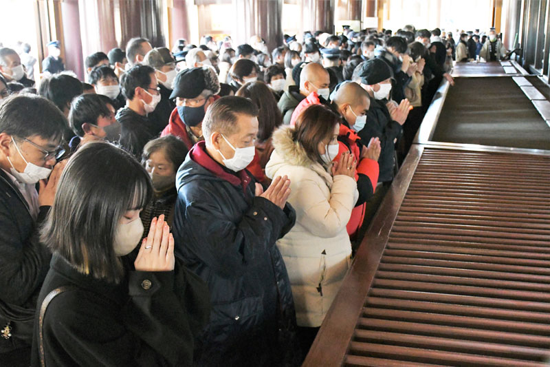 成田山新勝寺の大本堂で新年の願いを込めて手を合わせる初詣客＝１日午前、成田市