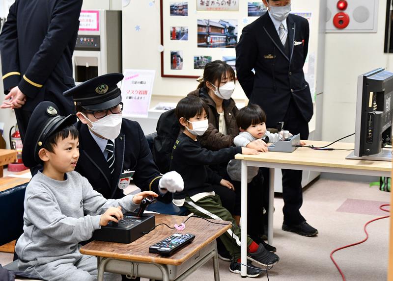 現役の運転士に教わりながら運転シミュレーターに挑戦する子どもたち＝５日、香取市