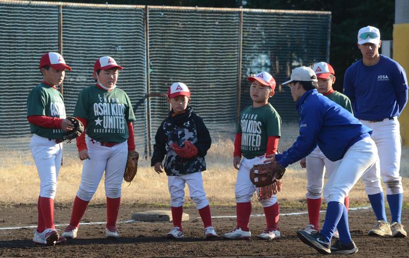 城西国際大野球部の選手に捕球を教わる児童ら＝東金市