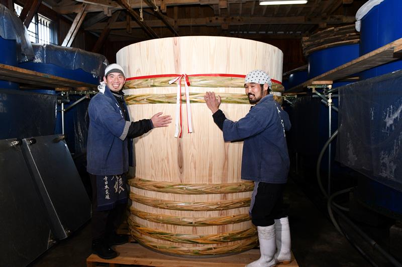 サンブスギを使った木桶と並ぶ寺田さん（左）と瀬戸さん＝神崎町の寺田本家