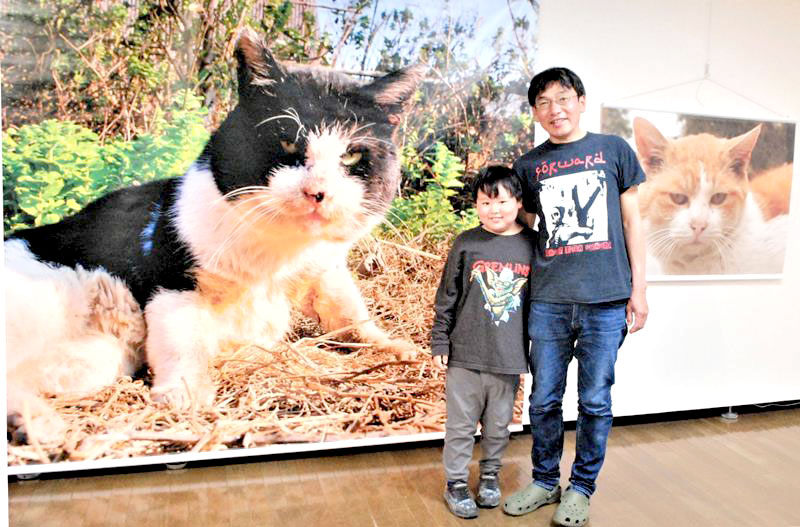 4年ぶりの写真展を開催中の津乗さんと息子の登亀雄君=船橋市