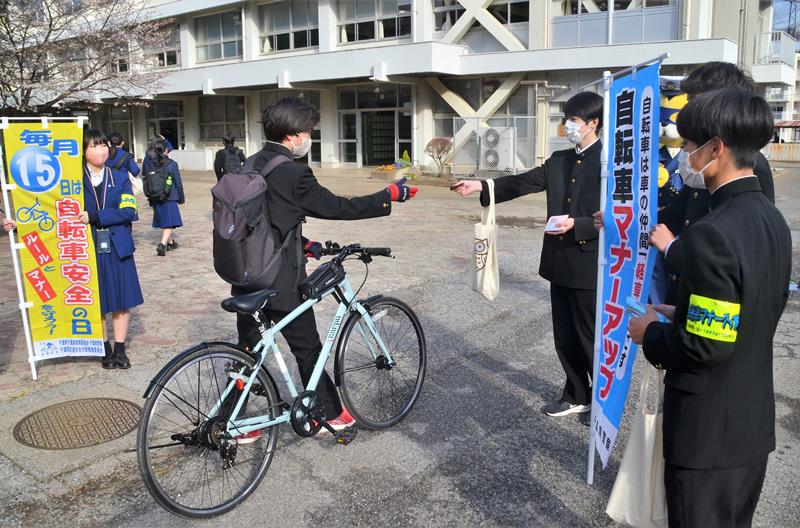 自転車で通学してきた生徒にチラシなどを配る風紀委員の１年生＝２０日、千葉市中央区の県立千葉南高校