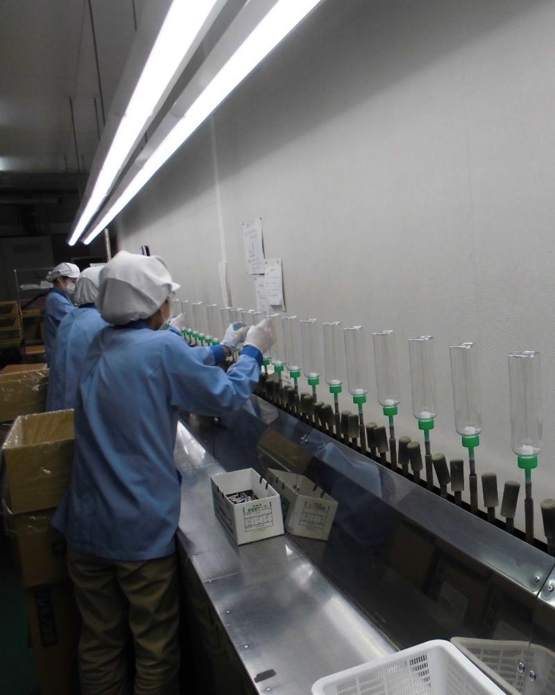 容器をラインに設置する従業員