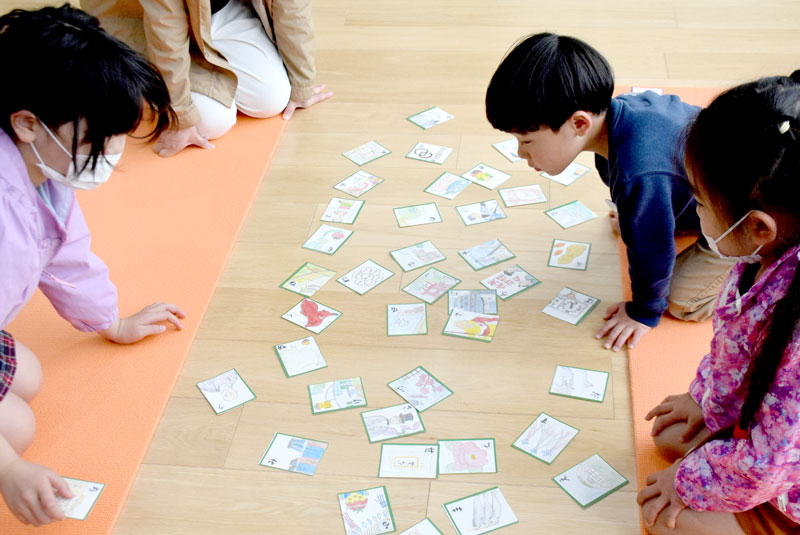 おひさまテラスのイベントで絵札を囲む子どもたち
