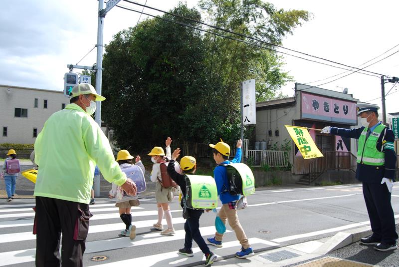 手を上げて横断歩道を渡る新１年生＝１７日、千葉市緑区の市立誉田東小