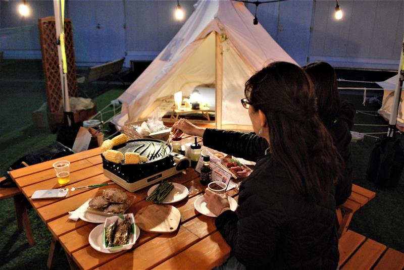 船橋東武の屋上にオープンしたバーベキュー施設で、大型連休期間にキャンプ気分を味わう女性客ら=船橋市