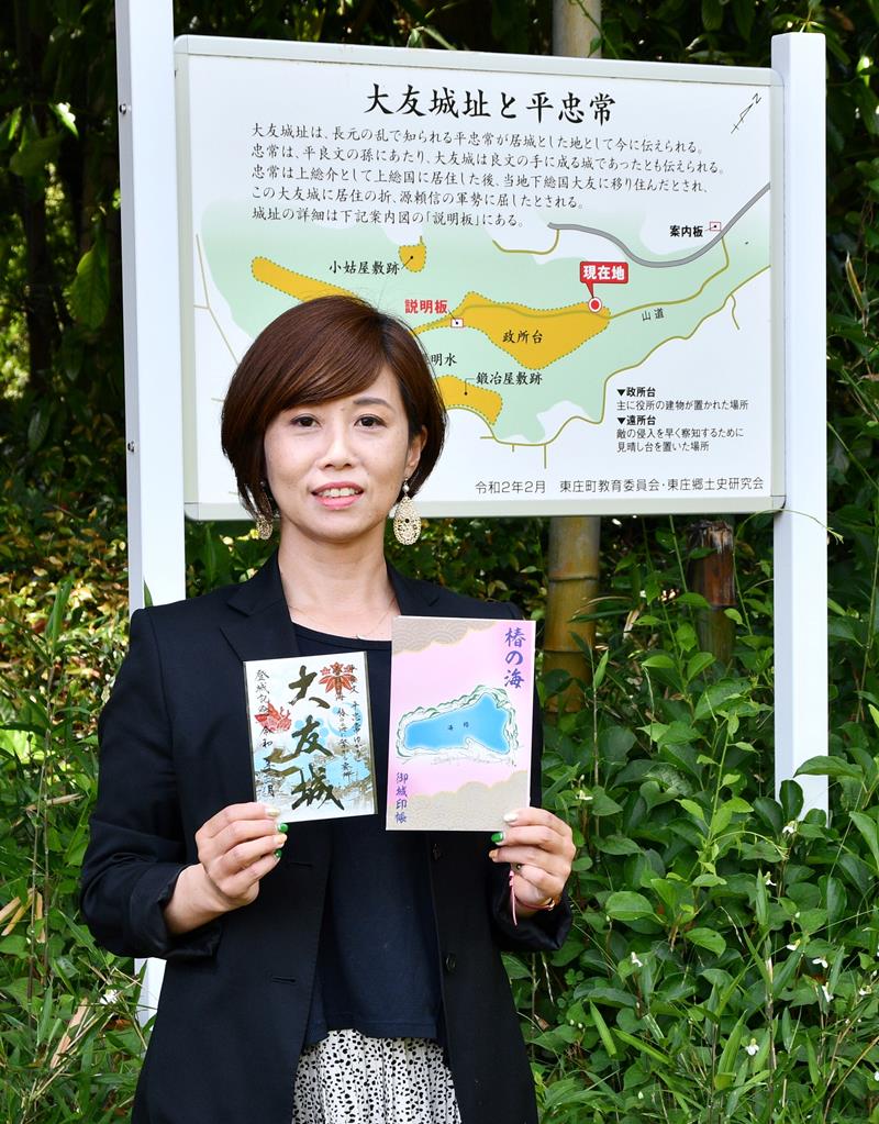 大友城の御城印と、椿の海の御城印帳を手に持つ山城ガールむつみさん=東庄町
