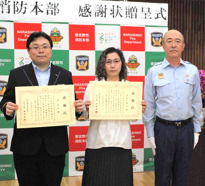 協力して心肺停止状態の男性を助け、感謝状を贈られた中島さん(中央)と星さん(左)=習志野市消防本部