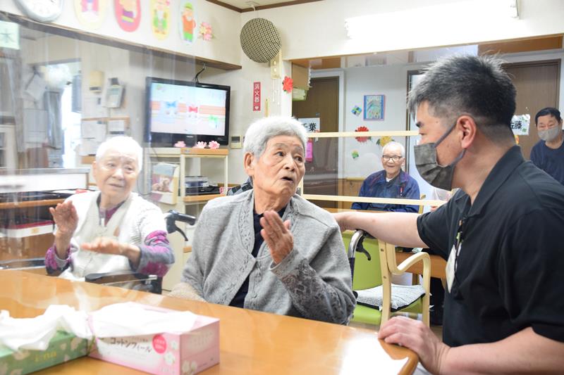 「おおこし」が運営する高齢者施設では、パーティションを置き、職員（右端）がマスクを着用するなど、従来からの感染対策を継続している＝７日、千葉市若葉区