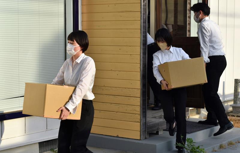 秋本衆院議員の地元事務所から、押収物が入っているとみられる段ボールを運び出す東京地検の係官ら=4日午後5時25分ごろ、佐倉市