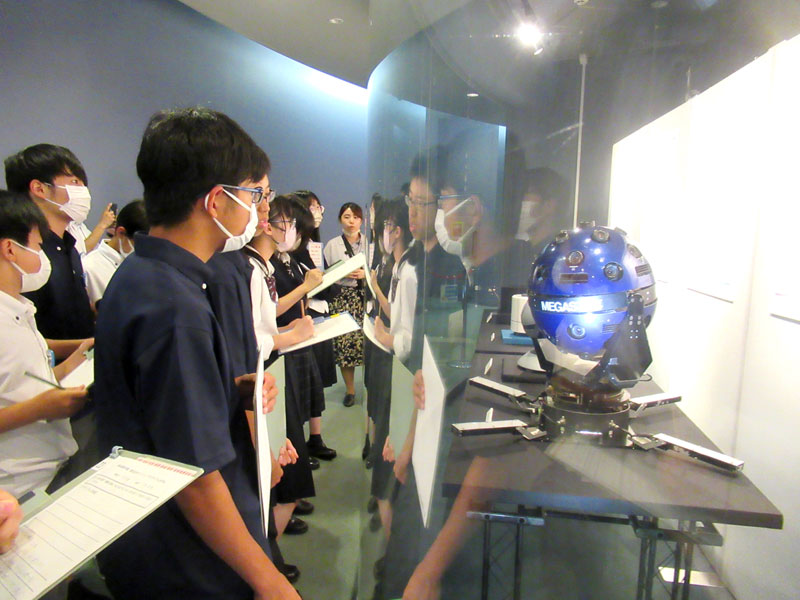 内覧会で、大平さんのプラネタリウム開発の歴史を教わる生徒ら