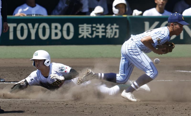 ７回裏専大松戸１死一、三塁、投前内野安打となるスクイズで一塁にヘッドスライディングする上迫田。（共同）