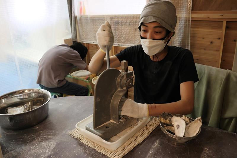 プレス機を使ってカキ殻を砕く作業をするITSUMOの利用者=千葉市若葉区