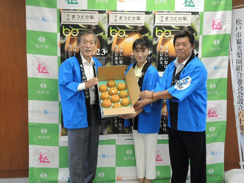 松戸市産の梨を寄贈した高橋会長(右)と山中会長(中央)。左は本郷谷市長=同市役所