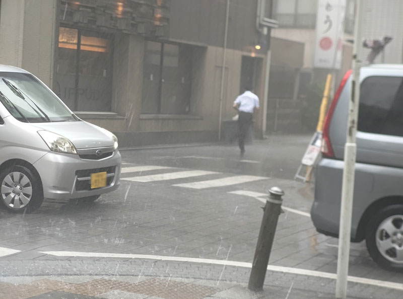 大雨の中走る男性＝１日午後０時半ごろ、千葉市中央区（画像は一部加工しています）