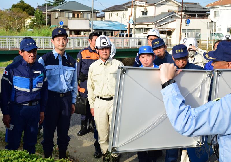 浸水地区で被災状況の説明を受ける松村祥史大臣（左）。熊谷俊人知事（左から２人目）らも同行した＝２７日午後、茂原市