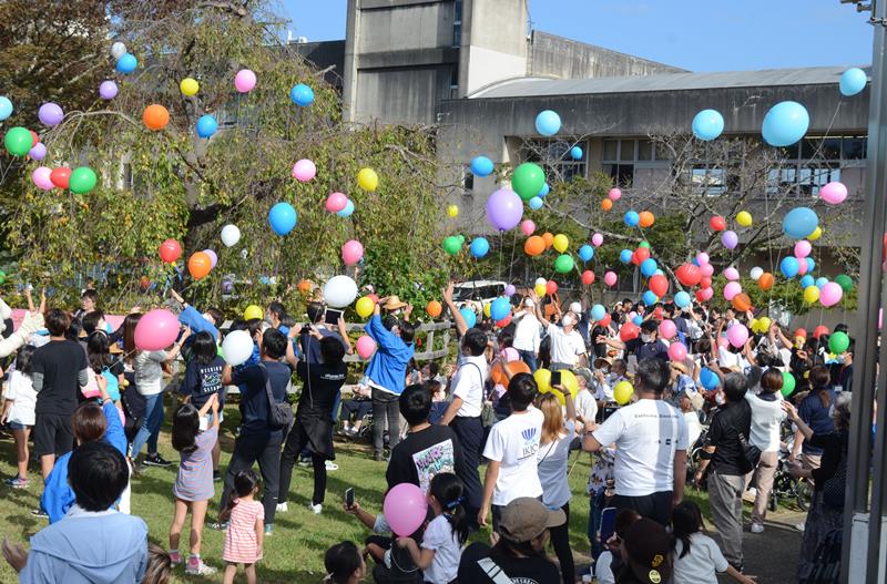 自然素材の風船を飛ばす参加者ら＝東金市