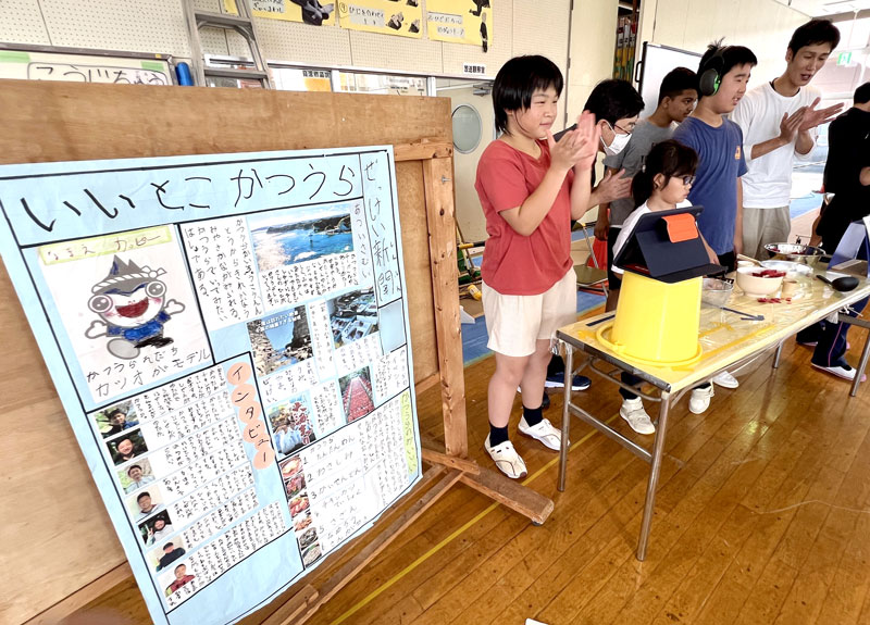手作りの新聞を発表する中学部１年の生徒。右は菊池教諭＝船橋市立船橋特別支援学校