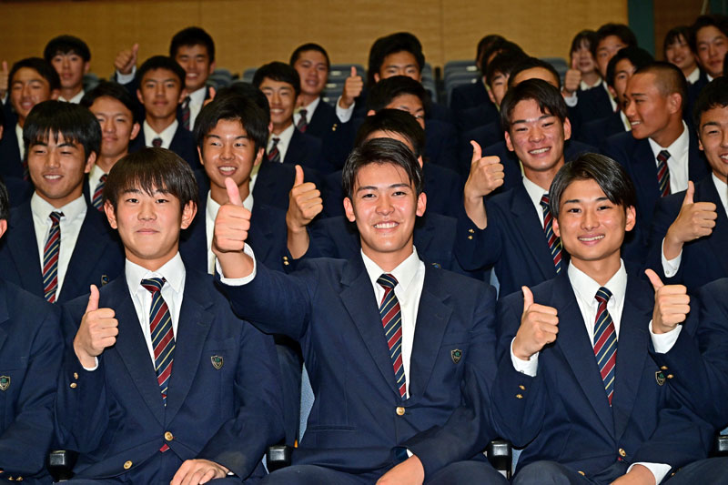 千葉ロッテ４位指名を受けチームメイトとポーズを取る幕張総合高の早坂響投手（前列中央）＝２６日、千葉市美浜区