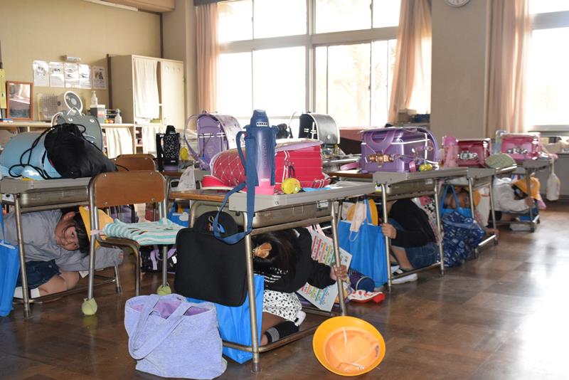 訓練で机の下に身を隠す児童たち＝銚子市