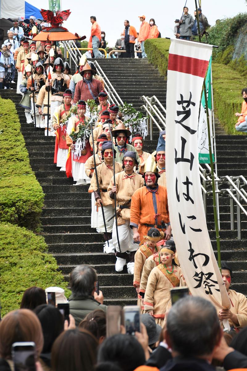 芝山公園に小中学生らがなりきる古代人が現れ、大勢の人が出迎えた=芝山町