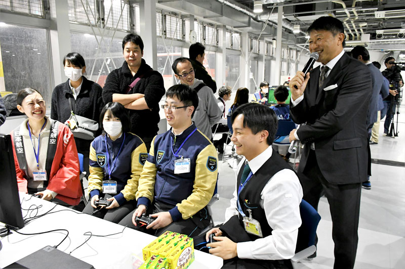 武田修宏さん（右）に見守られながらサッカーゲームをプレーして交流する成田空港の若手従業員たち＝成田市