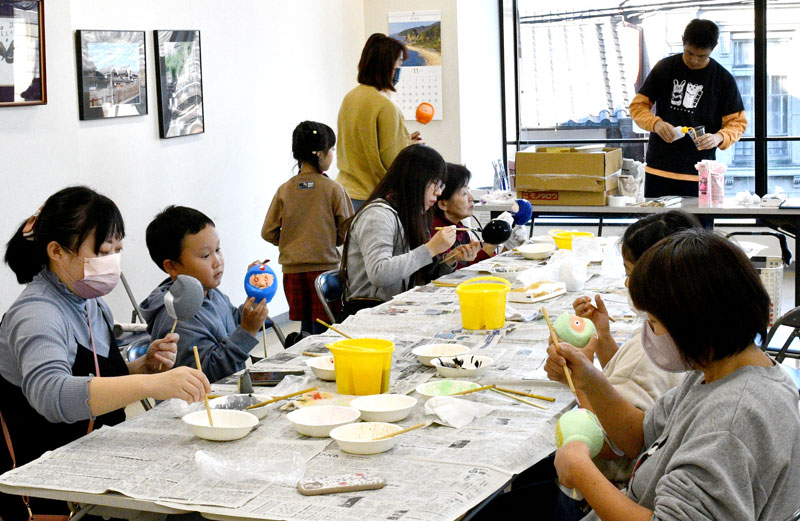 思い思いにだるまの張り子に色を付ける参加者＝香取市