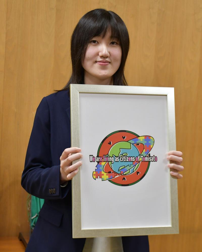 多文化共生に向けて作成したロゴを紹介する本多さん＝富里市役所