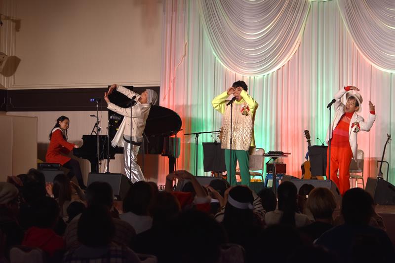 24日の公演で「わ!」を歌う(右から)田中さん、横山さん、杉田さん。歌に合わせて観客もおのおのの輪を作っていた=千葉市美浜区