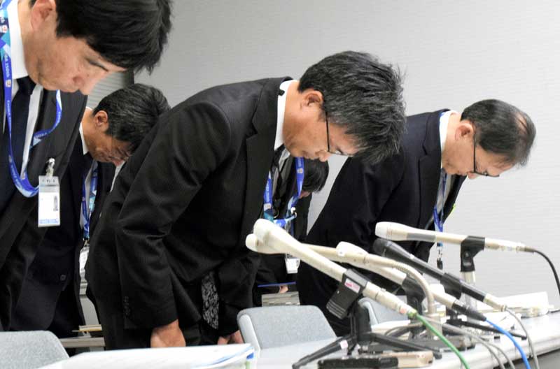 千葉県職員の逮捕を受け、記者会見冒頭に頭を下げて謝罪する池口県土整備部長(中央)=10日、県庁