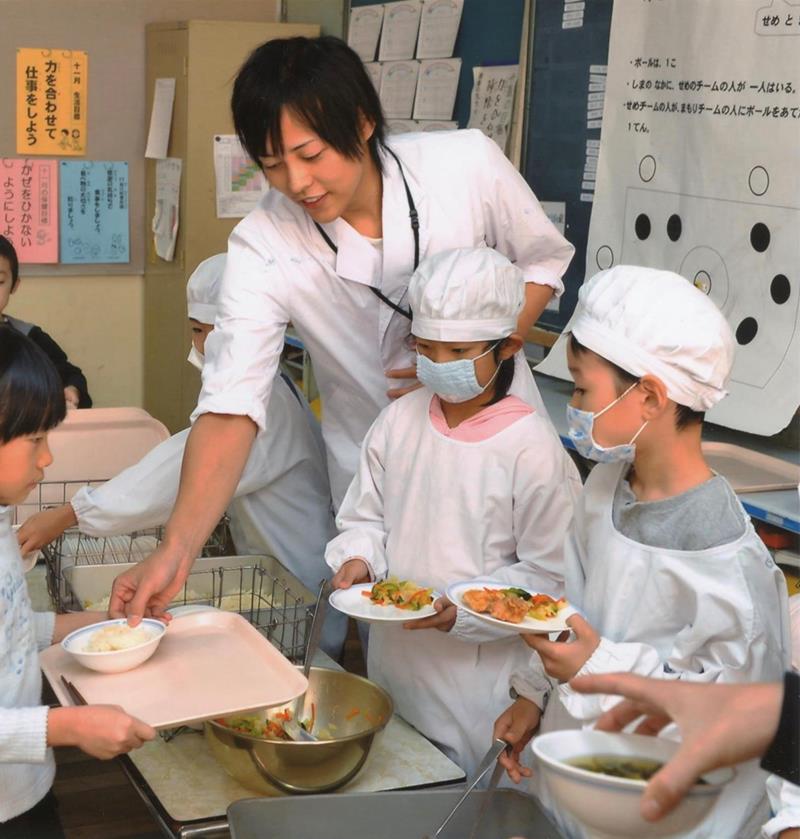 配膳の仕方を指導する松丸さん(本人提供)