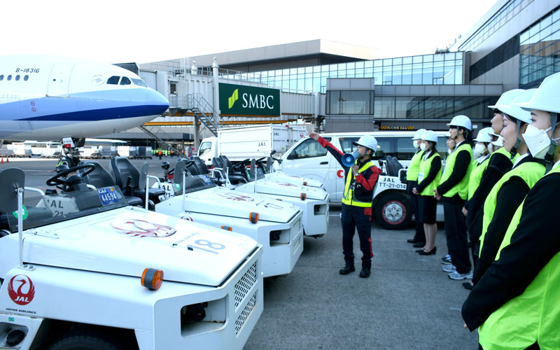 駐機場に航空機が到着した際の業務について説明を受ける大学生たち＝成田市の成田空港