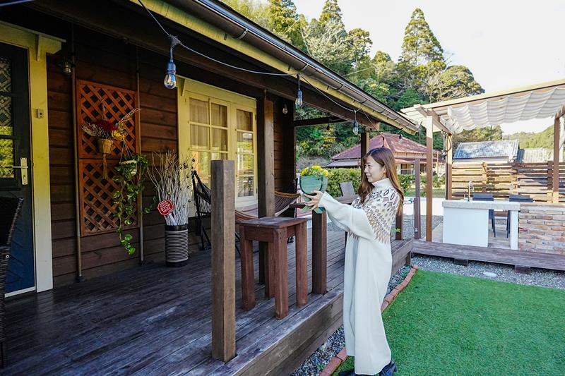 経営する１棟貸しログハウスに花を飾る清水さん＝御宿町高山田