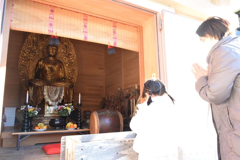 開帳された本尊の木造薬師如来坐像に手を合わせる人たち＝８日、銚子市