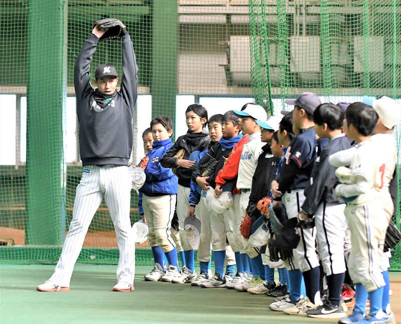 「体を大きく使って投げよう」と指導する千葉ロッテの菊地選手＝１４日、千葉市美浜区