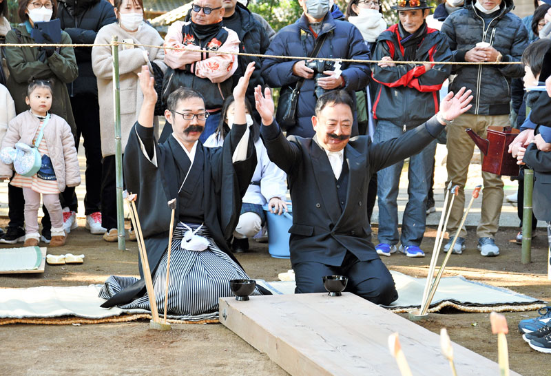 正座で口ひげをなでてから、酒を勧め合う＝１４日、香取市の側高神社