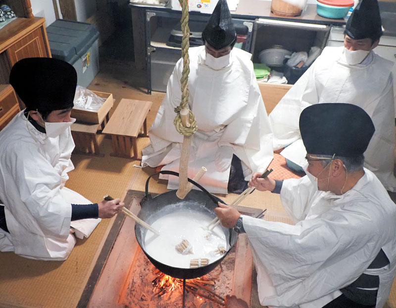 「筒粥」神事で葦の束をかゆの中に入れて煮込む神職たち＝１５日午前１時ごろ、袖ケ浦市