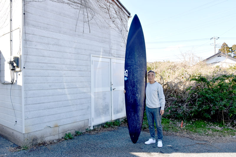 ハワイの大波に挑む紫色のサーフボードを手にする蛸さん＝いすみ市