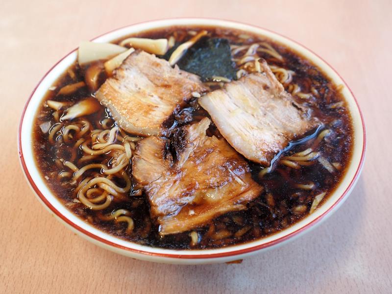 まっ黒な濃厚しょうゆ味のラーメン。厚切りチャーシューや乾麺とよくなじむ