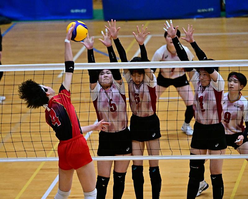 習志野―敬愛学園　第２セット、ブロックに跳ぶ敬愛学園の永盛（５）、加藤（６）、諸橋（４）＝東金アリーナ