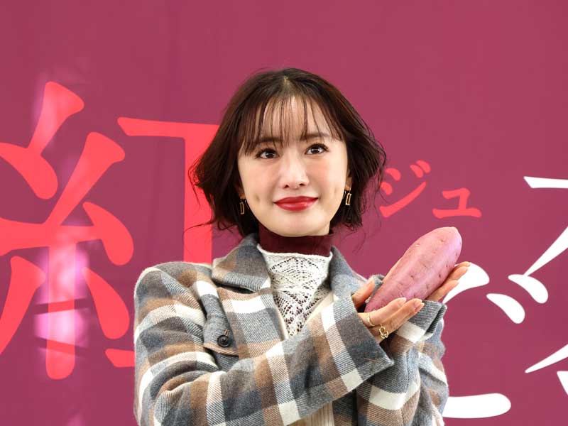 サツマイモを手に笑顔を見せる松本さん=3日午後、千葉市美浜区のイオンモール幕張新都心