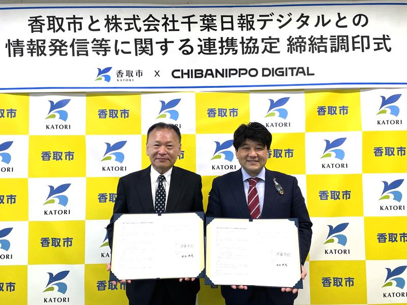 協定書を手にする伊藤市長（右）と松本社長＝２７日、香取市役所