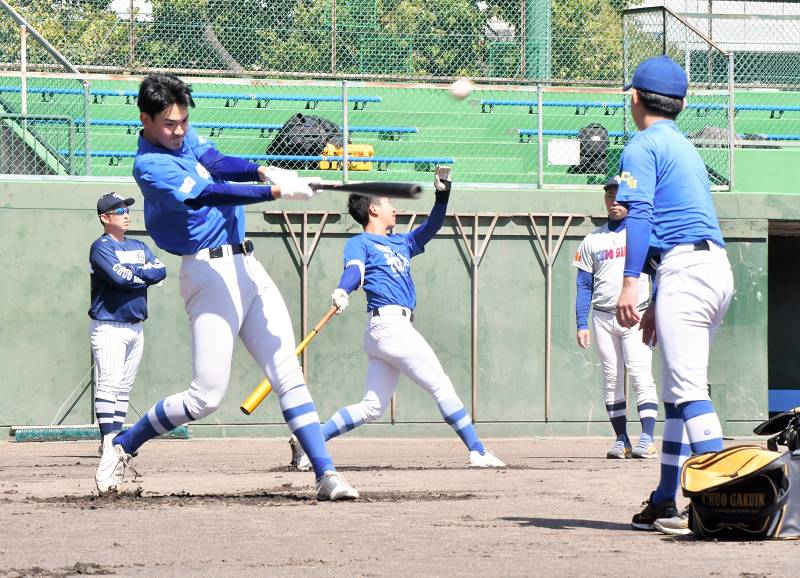 準決勝に向けてトス打撃に取り組む中央学院の蔵並（手前左）、小沢（中央奥）＝兵庫県西宮市