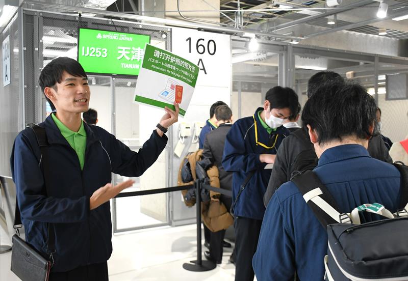 機内清掃業務から成田空港の地上係員に転身したＪＧＳの雲野さん。第３ターミナルの搭乗口で中国に向かう旅客を案内している＝成田市