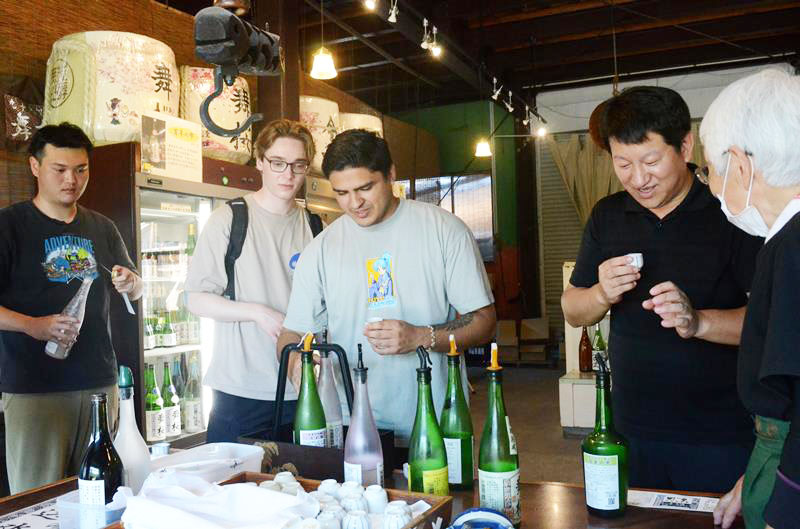 地元高校生が企画したツアーで試飲を楽しむ城西国際大の留学生＝昨年７月