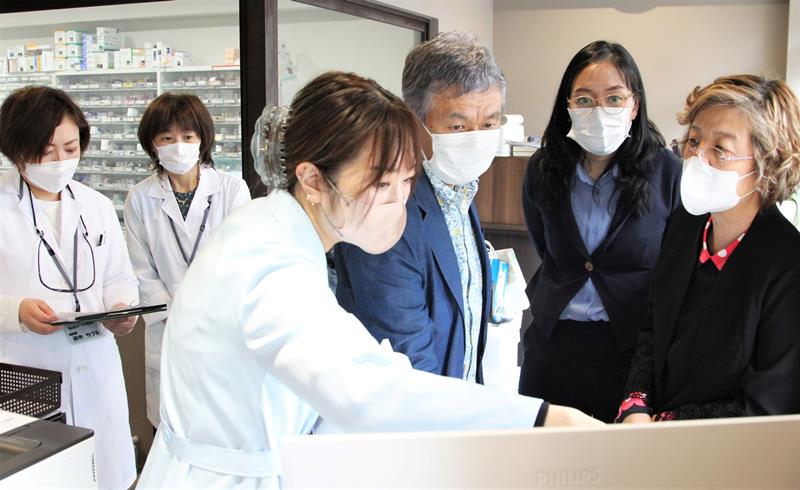 日本の薬局のシステムについて、薬剤師らから説明を受けるタイの准教授（右から１人目）と大学院生（同２人目）＝千葉市中央区