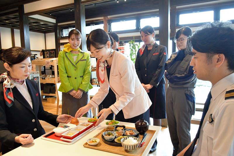 「お仕事紹介し隊」の役目を兼ねて、御料鶴のフロアに立つため、料理提供の練習をするパイロットや地上係員ら＝４月２２日、成田市の同店