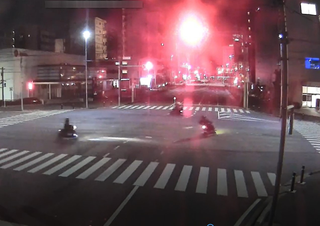バイクに乗った容疑者らの危険行為が防犯カメラに映っていた(県警提供、写真は動画の一部より)