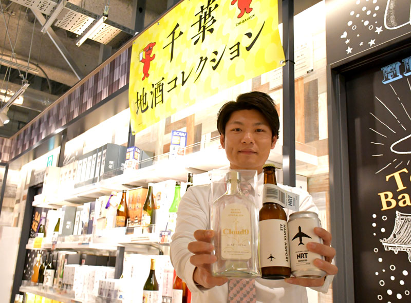 県産の材料を使って作った「成田空港エール」とオリジナルのジンを紹介する成田空港の土産店スタッフ＝成田市