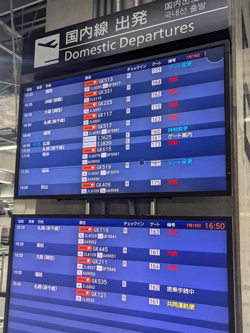 欠航便を伝える成田空港第３ターミナルの電光掲示板＝１９日、成田市